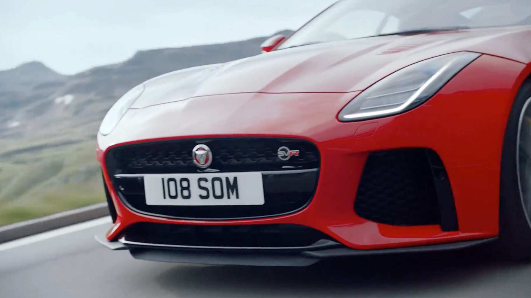 A close up of the front of a jaguar f-type as it drived along a road.
