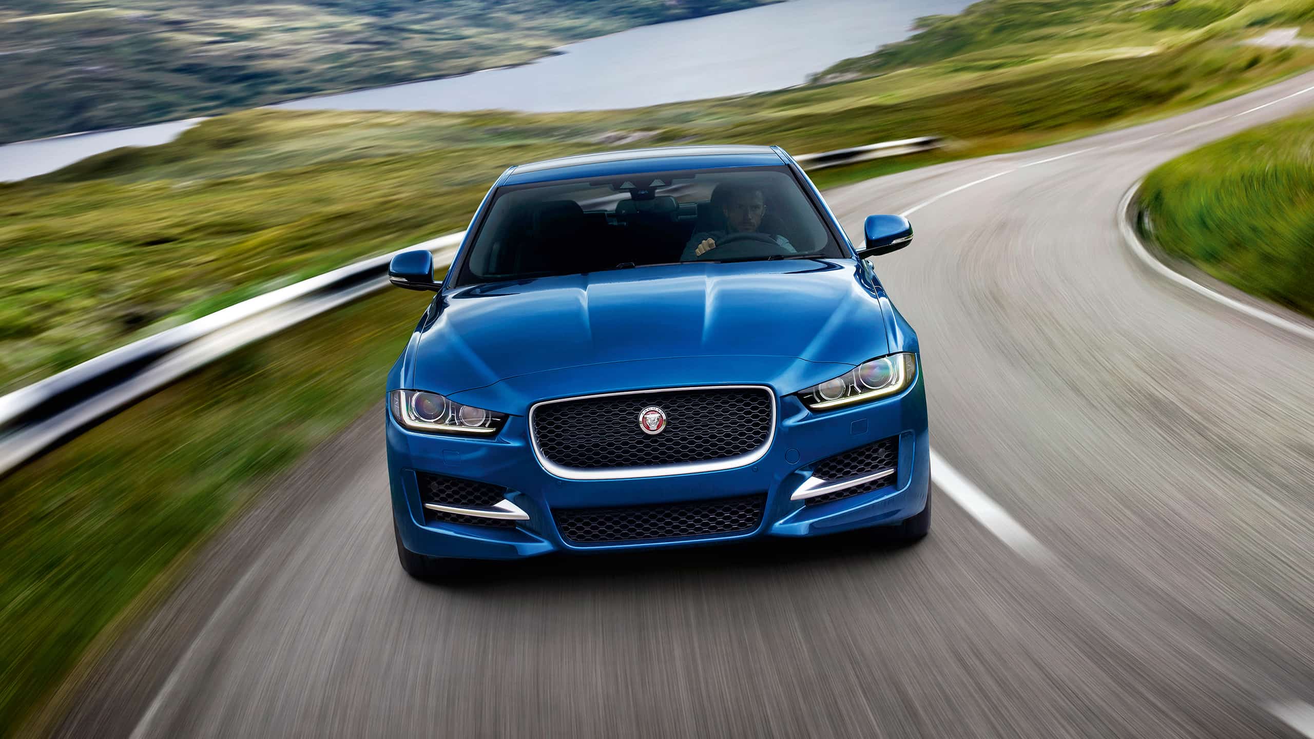 Jaguar XE Moving on Hilly River Road